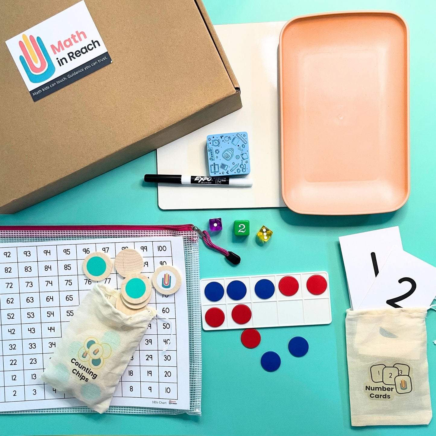 Educational materials Math in Reach Starter Kit flat lay with counting chips, number cards, dice, ten-frame, whiteboard, tray, and storage pouch on teal background.